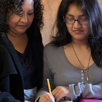 Photo of two women at work - Georgia Family Connection looks for a solution that tracks contacts and share application files