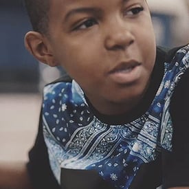 A teen-aged African-American male student doing homework in class