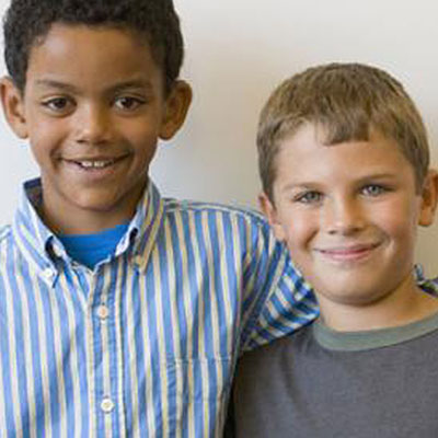Two young boys smiling and looking at the camera