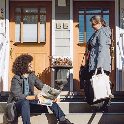Neighbors conversing on the front porch of their homes