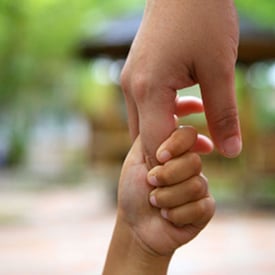 Close up photo of a father's hand holding a child's hand
