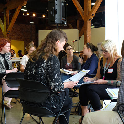 A group of six women sitting in a circle for an informal meeting