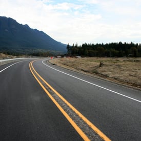 A highway with yellow line in a mountainous landscape