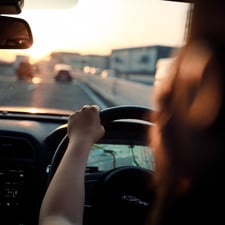 A car driver looking through windshield while driving through a town