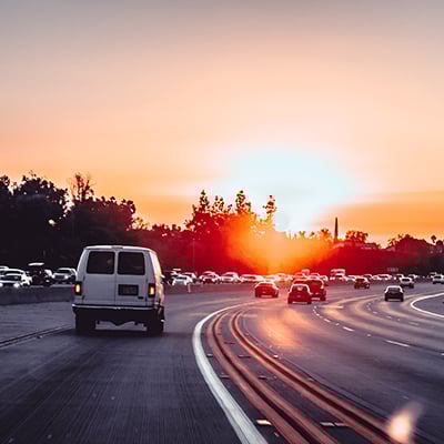 Highway traffic heading into a sunset
