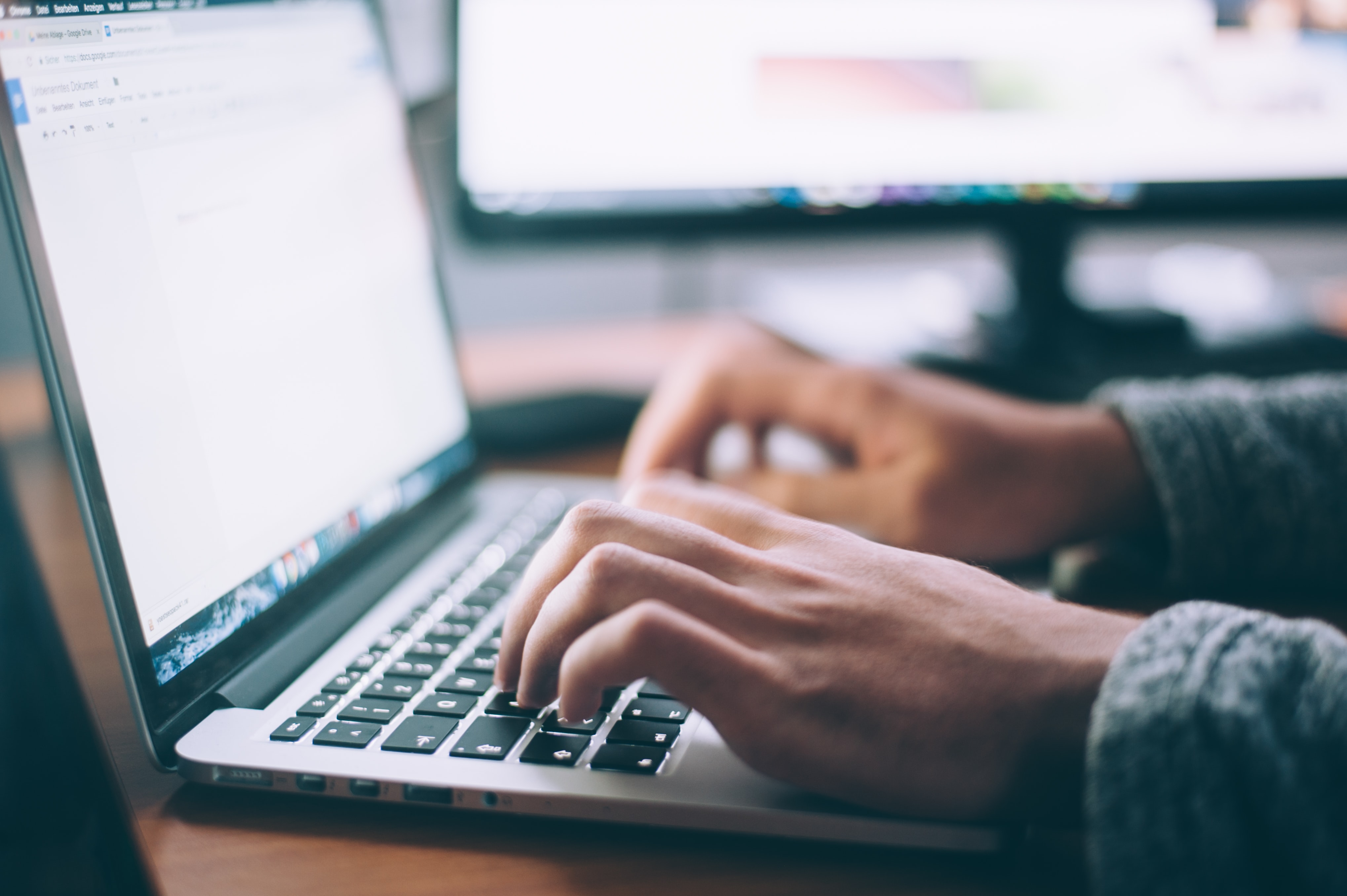 Hands typing on a computer