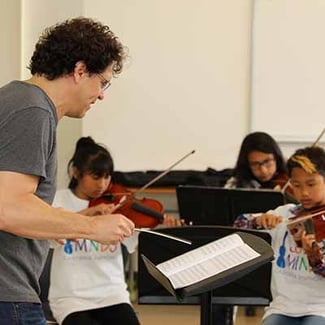 A music conductor working with children musicians