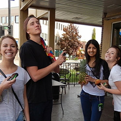 A young man and 3 young women smiling and posing for the camera